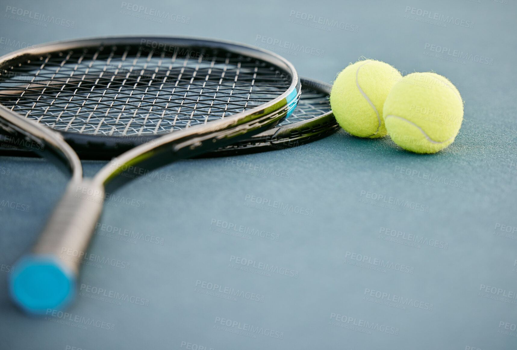 Buy stock photo Shot of two tennis rackets and tennis balls on a court during the day