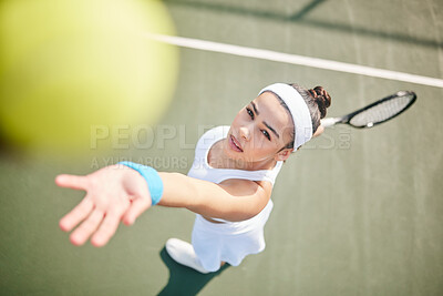 Buy stock photo High angle shot of young tennis player standing alone on the court and serving the ball during practice