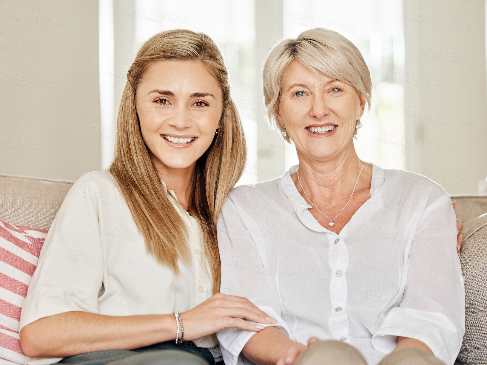 Buy stock photo Shot of a mother and daughter sitting on the couch at home