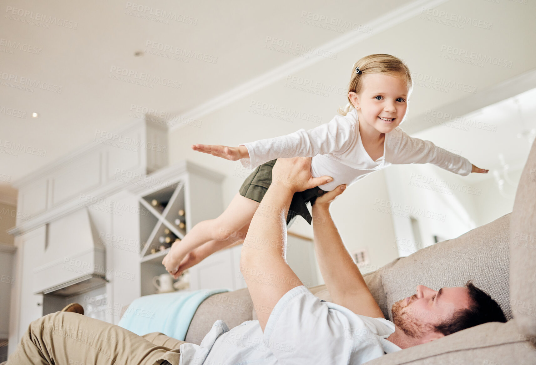 Buy stock photo Girl, child and father with flying on sofa for game in home with imagination, playing and support with smile. Kid, airplane fantasy and balance with trust, portrait and bonding with lifting in house