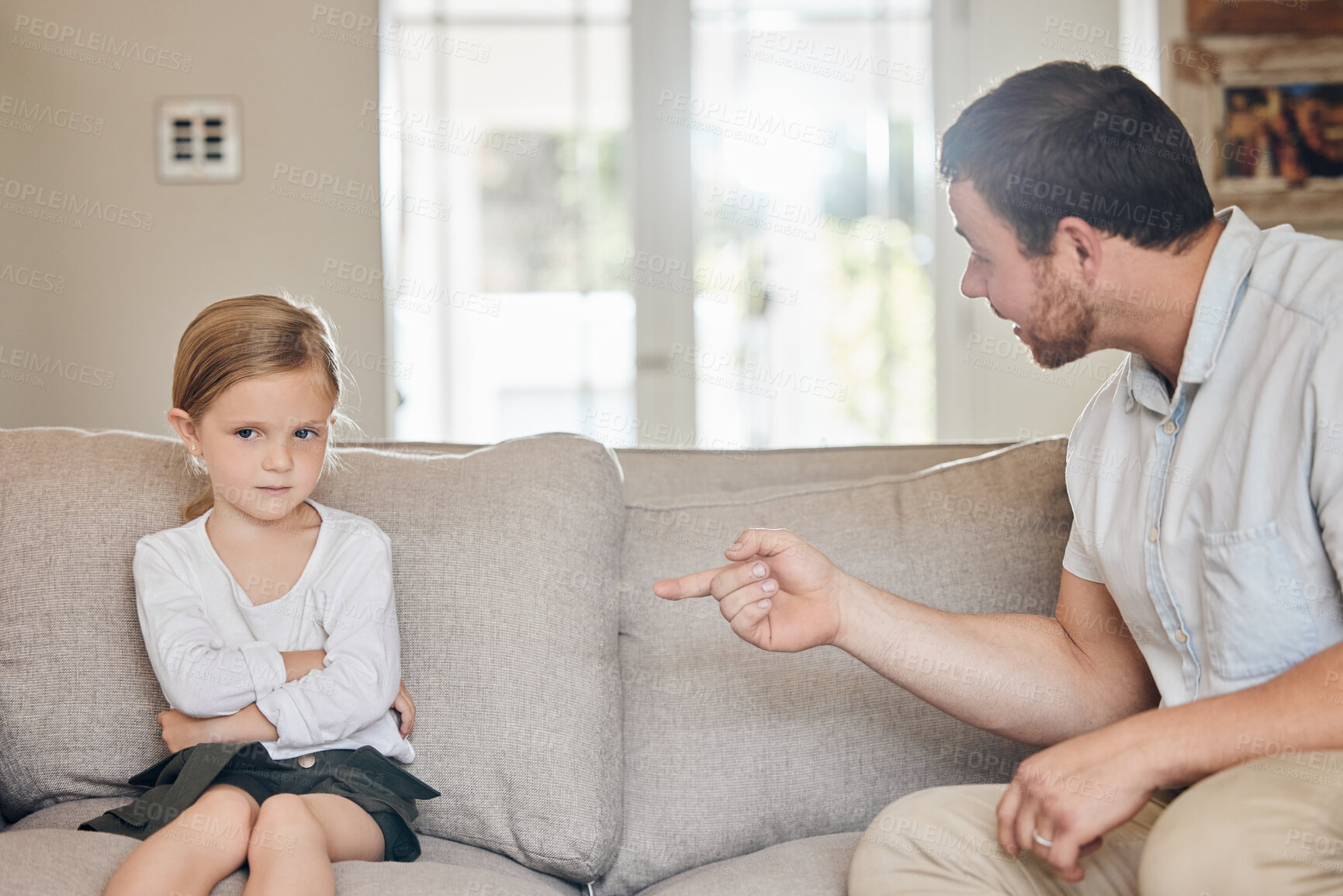 Buy stock photo Upset, child and dad with discipline on sofa for bad behaviour, confrontation or punishment in living room. Home, disappointed and strict man pointing at young girl for fight, mistake or scolding