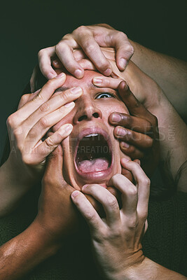 Buy stock photo Shot of hands grabbing a young woman’s face against a dark background