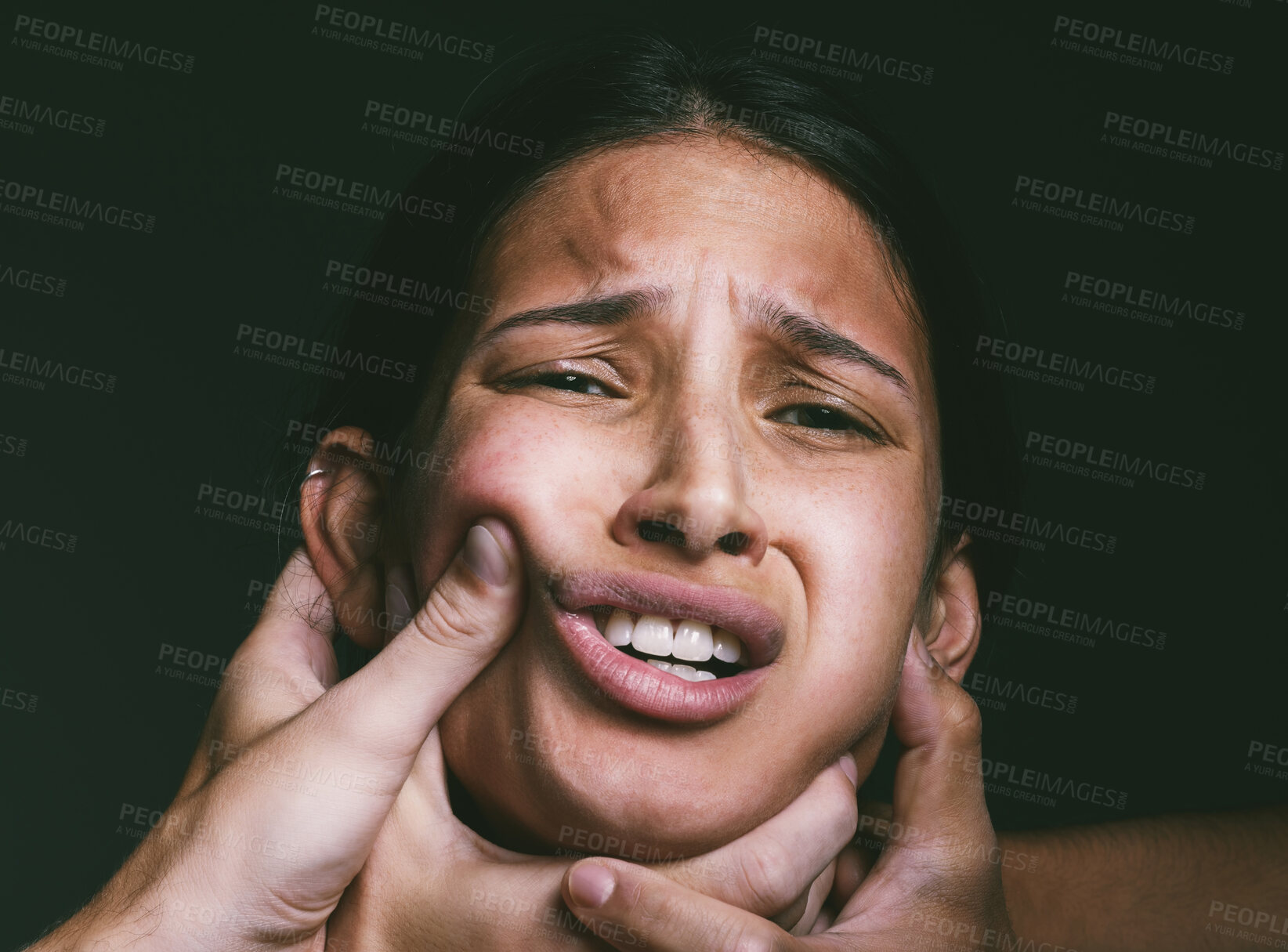 Buy stock photo Shot of hands grabbing a young woman’s neck against a dark background