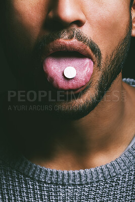 Buy stock photo Shot of an unrecognisable man taking a pill against a dark background