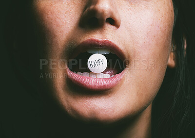 Buy stock photo Shot of an unrecognisable woman taking a pill with the word ‘happy’ written on it
