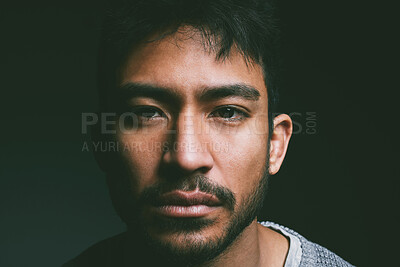 Buy stock photo Studio shot of a young man staring blankly against a dark background