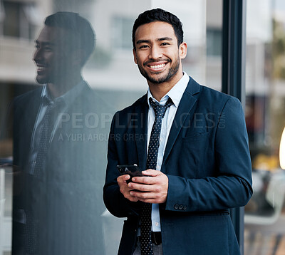 Buy stock photo Shot of a handsome young businessman standing in the city and using his cellphone