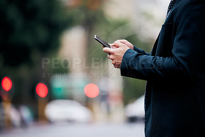 Buy stock photo Shot of an unrecognizable businessman standing and using his cellphone in the city