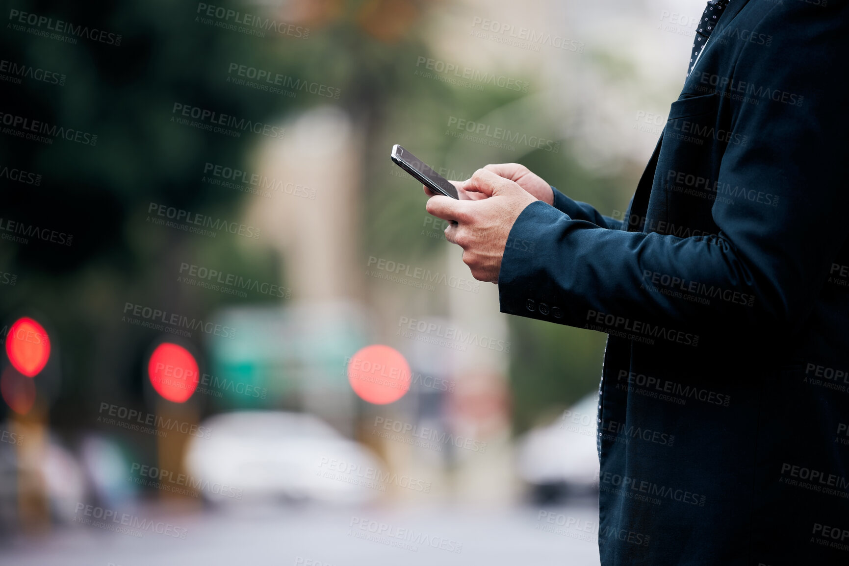 Buy stock photo Shot of an unrecognizable businessman standing and using his cellphone in the city