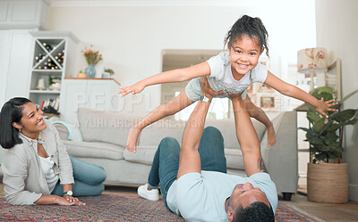 Buy stock photo Shot of an adorable little girl bonding with her parents in the living room at home