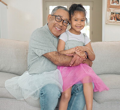 Buy stock photo Shot of an adorable little girl bonding with her grandfather in the living room at home