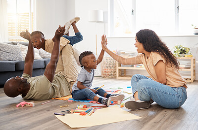 Buy stock photo Shot of a happy young woman giving her son a high five during family play time at home