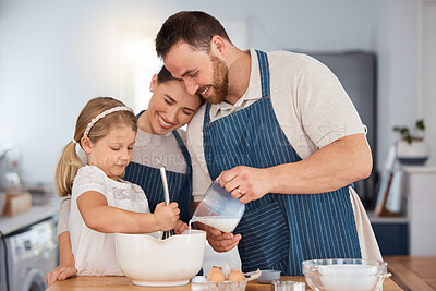 Buy stock photo Shot of a young couple and their daughter baking together at home