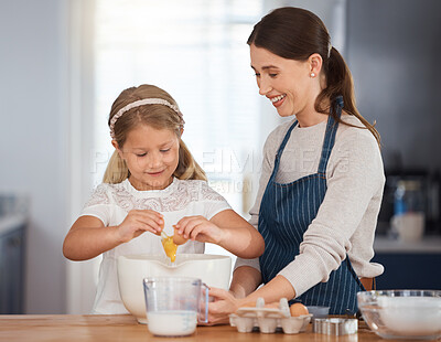 Buy stock photo Shot of an adorable little girl assisting her mother while baking at home