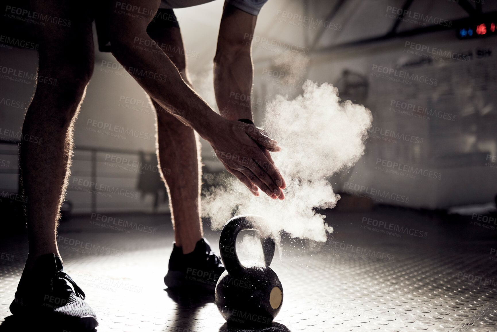 Buy stock photo Shot of an unrecognisable man rubbing sports chalk on his hands while exercising with a kettlebell in a gym