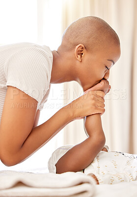 Buy stock photo Shot of a mother kissing her baby daughter's feet at home