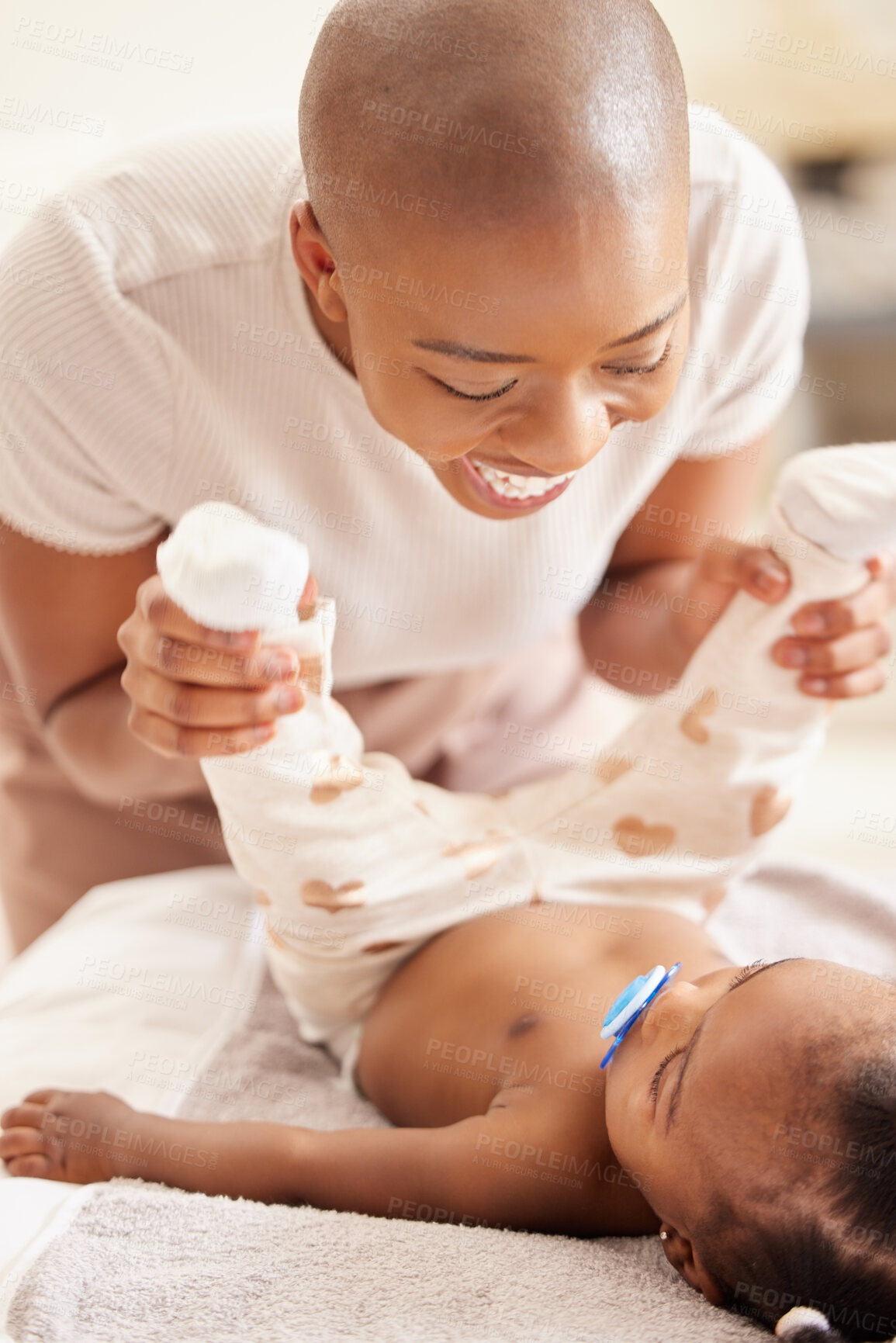 Buy stock photo Shot of a mother changing her baby daughter's clothing at home