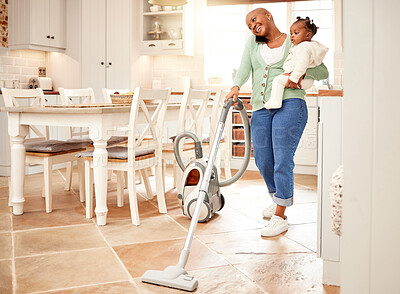 Buy stock photo Full length shot of an attractive young woman vacuuming and making a phonecall while carrying her daughter at home