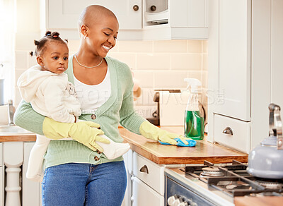 Buy stock photo Cropped shot of an attractive young woman carrying her daugher while doing chores at home