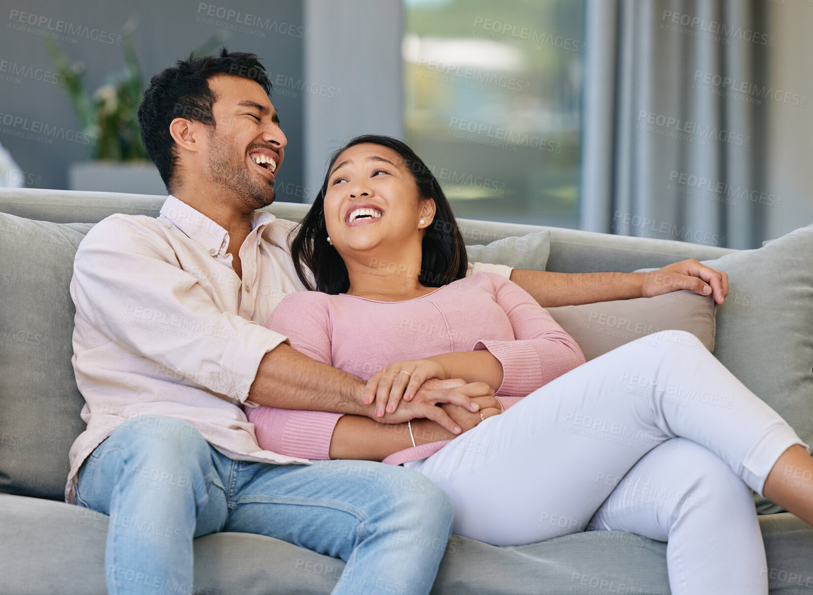 Buy stock photo Asian couple, happiness and relax on sofa in living room for love, support or conversation. Laughing, weekend and married man with funny woman in lounge for joke, comedy or bonding together in home