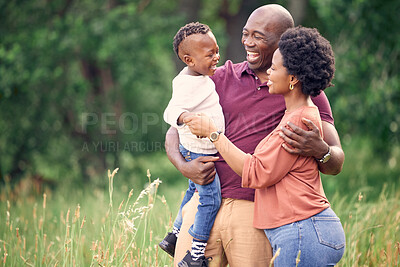 Buy stock photo Shot of a happy couple spending the day outdoors with their son