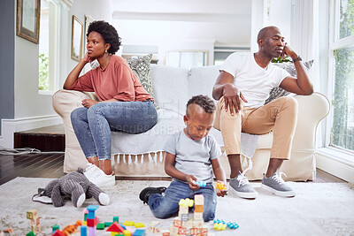 Buy stock photo Family, fight and couple argue on a sofa, stress and divorce with playing child on a living room floor. Marriage, crisis and angry woman with man on couch after conflict, argument or problem with son