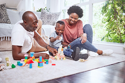 Buy stock photo Toys, building blocks and black family playing on a living room floor happy, love and bonding in their home. Child development, learning and kid with parents in a lounge with alphabet, shape and game