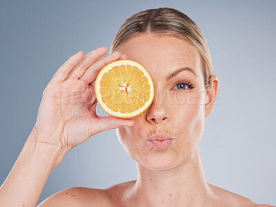 Buy stock photo Skincare, orange and portrait of model in studio for facial treatment, natural glow or wellness on gray background. Clean, beauty and hand of woman with kiss lips for vitamin c, eco or dermatology