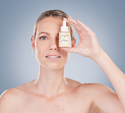 Buy stock photo Woman, portrait and serum bottle for skincare in studio on grey background with routine, ingredients and satisfied for results. Girl, natural and confidence with facial treatment and skin product