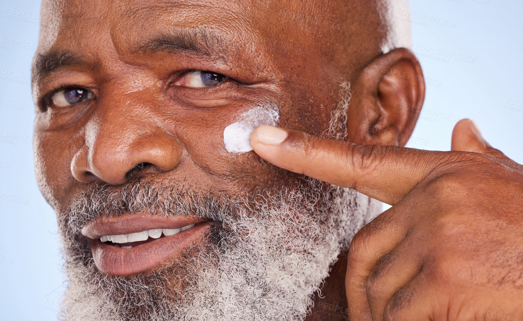 Buy stock photo Skincare, cream and portrait of black man in studio for sunscreen, anti aging or beauty. Cosmetics, closeup or self care with lotion on face of model on blue background for facial, spa and  product