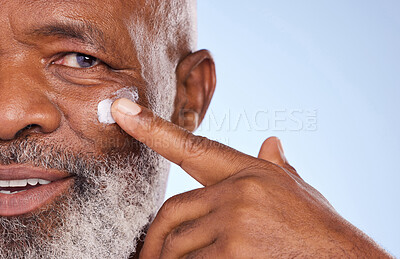 Buy stock photo Skincare, cream and closeup of black man in studio for sunscreen anti aging or beauty. Cosmetics, mockup or self care with lotion on face of senior model on blue background for facial and spa product