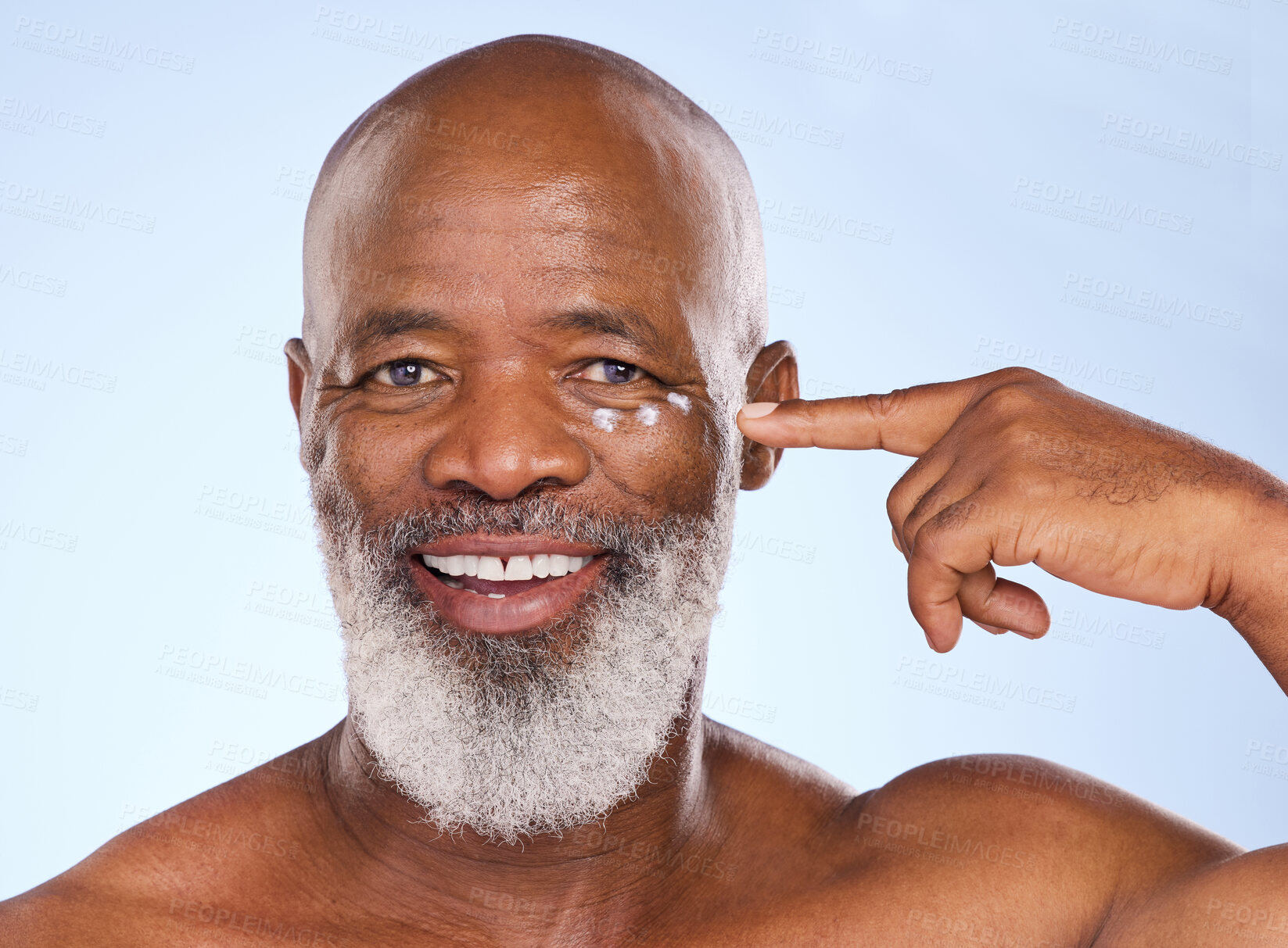 Buy stock photo Portrait, black man and cream for skincare, beauty and studio for application on blue background. Sunscreen, protection or anti aging with lotion for male person, eye and wrinkle product treatment