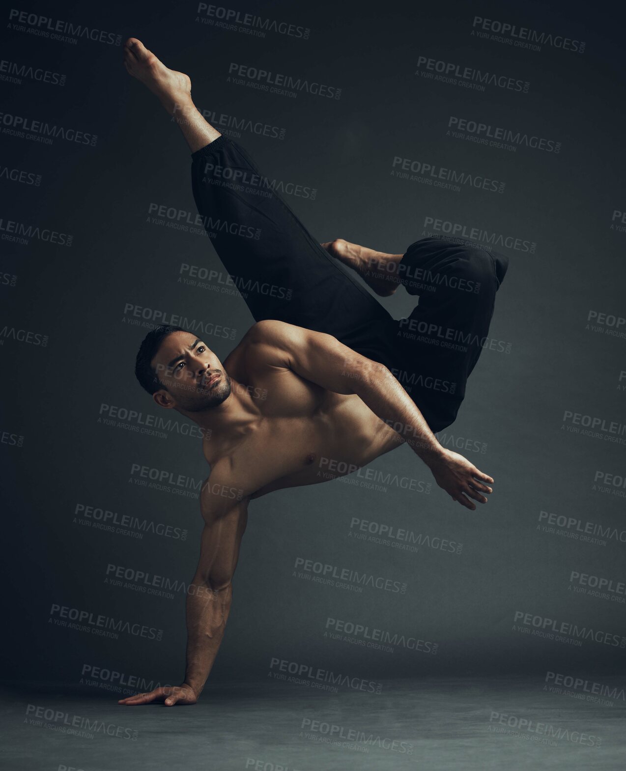 Buy stock photo Full length shot of a handsome young man performing a martial arts kick in the studio