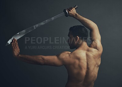 Buy stock photo Shot of an unrecognisable man standing alone in the studio and posing with a broadsword