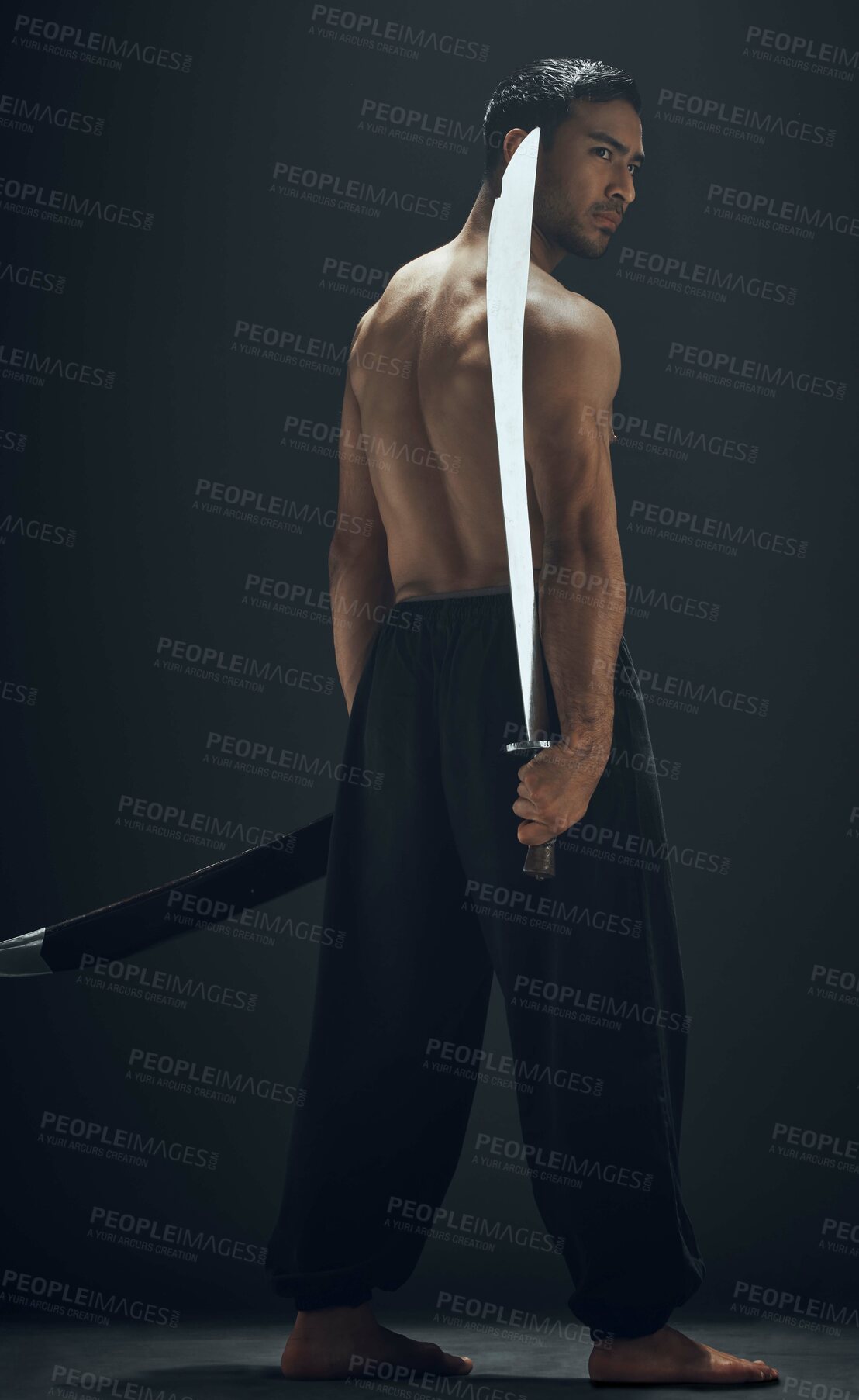 Buy stock photo Full length shot of a handsome young man standing alone in the studio and posing with a broadsword