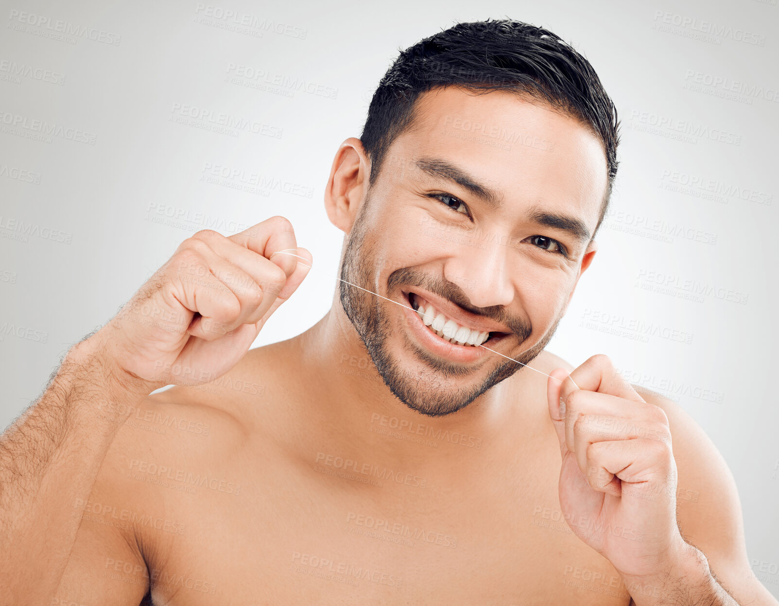 Buy stock photo Portrait, hygiene and man flossing in studio with smile for healthy gums and plaque removal. Cleaning teeth, Asian guy and dental string for healthcare and gingivitis prevention by white background