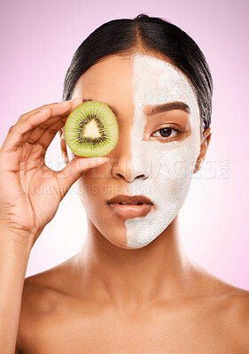 Buy stock photo Studio shot of an attractive young woman holding kiwi fruit to her face against a pink background