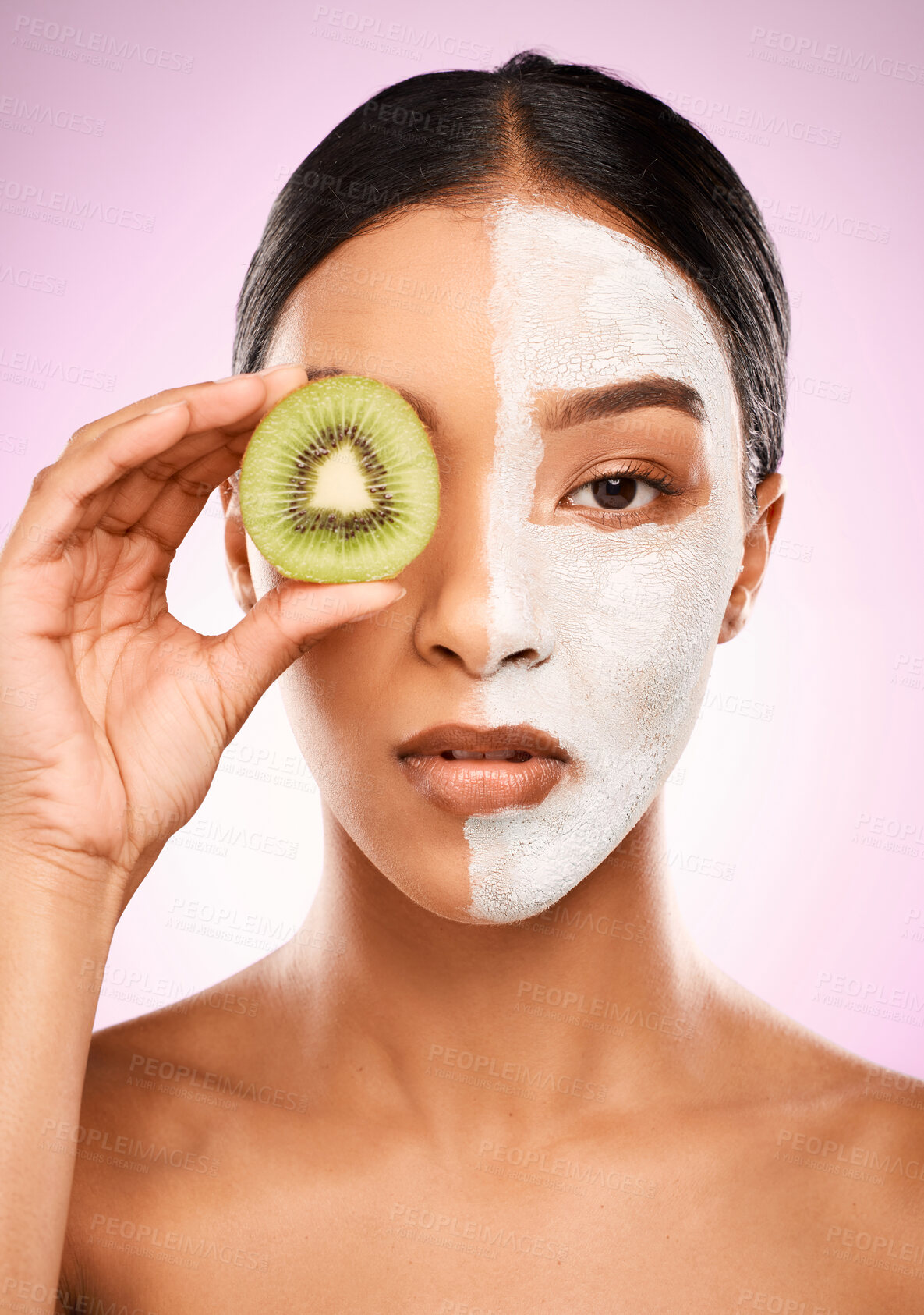 Buy stock photo Woman, facial mask and kiwi in studio for treatment, vegan and organic skincare on pink background. Female person, eye and half for comparison results, eco friendly cosmetics and natural dermatology