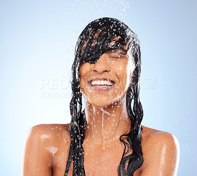 Buy stock photo Studio shot of an attractive young woman taking a shower against a blue background