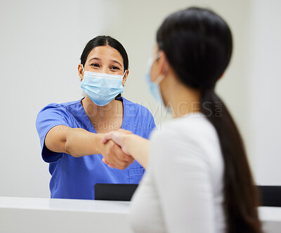 Buy stock photo Shot of a nurse and patient shaking hands in a clinic