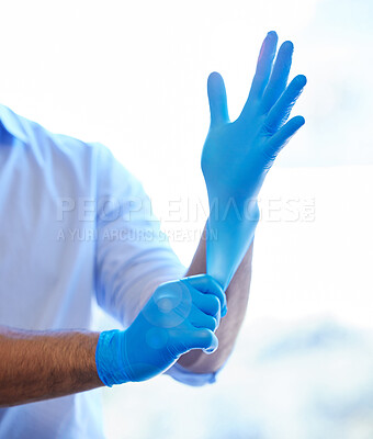 Buy stock photo Shot of an unrecognisable dentist putting on rubber gloves