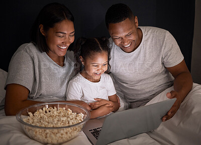 Buy stock photo Happy family, night and popcorn with laptop in bedroom for chill, unwind and weekend relax for movies. Mother, father and child in dark home with internet for streaming, videos and cartoon film.