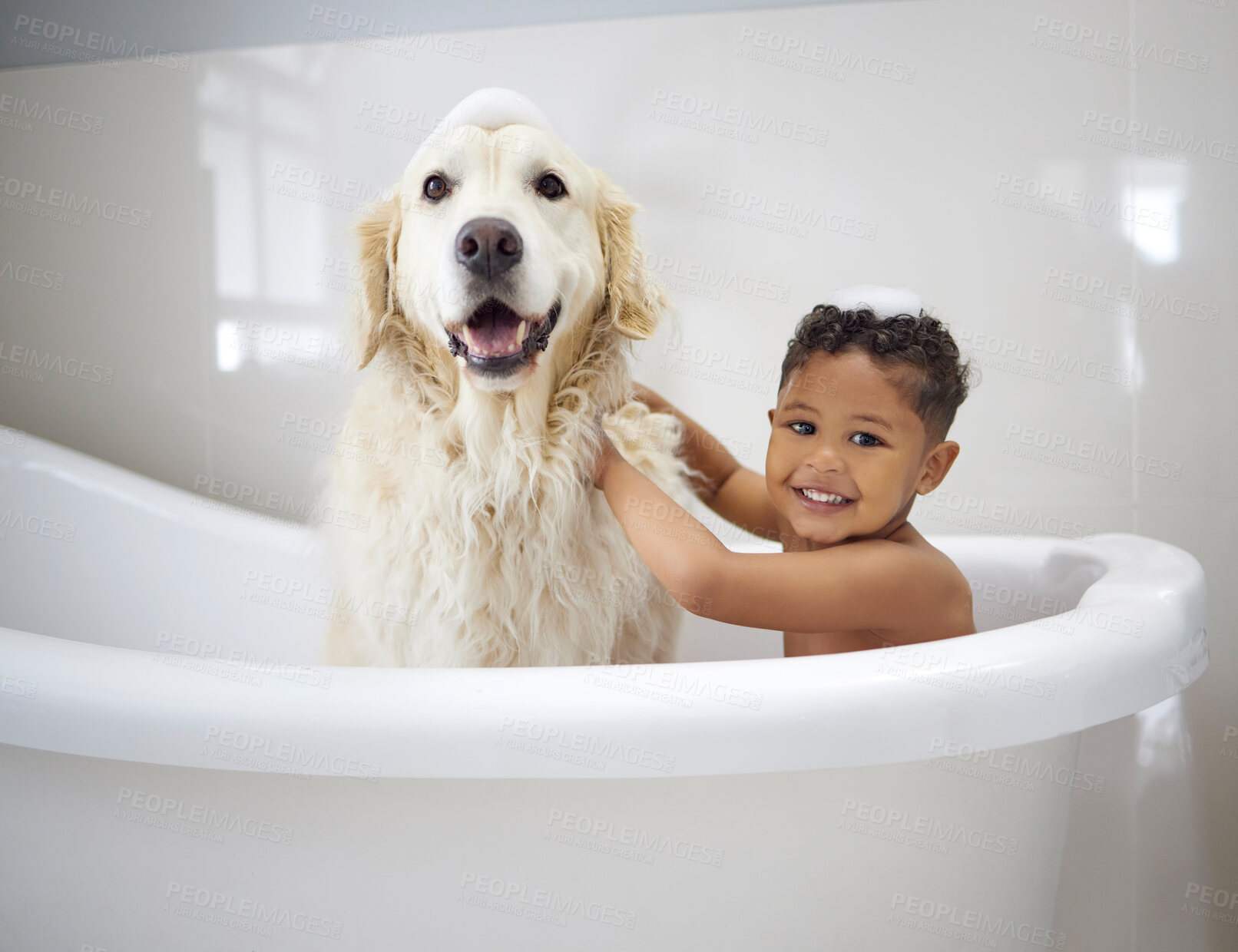 Buy stock photo Shot of an adorable little boy sitting in the bathtub with his Golden Retriever during bath time at home