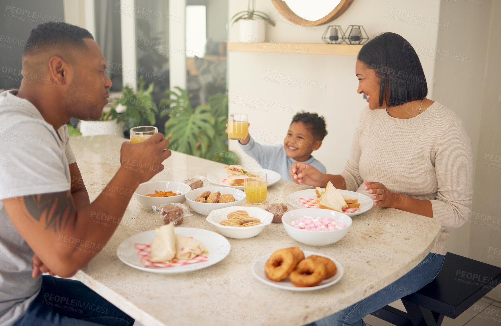 Buy stock photo Breakfast, family and juice at dining room table of home for diet, nutrition or wellness together. Food, love or smile with mother, father and son in apartment for bonding, child development or meal