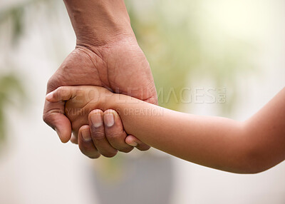 Buy stock photo Shot of an unrecognisable man holding hands with his child in a garden