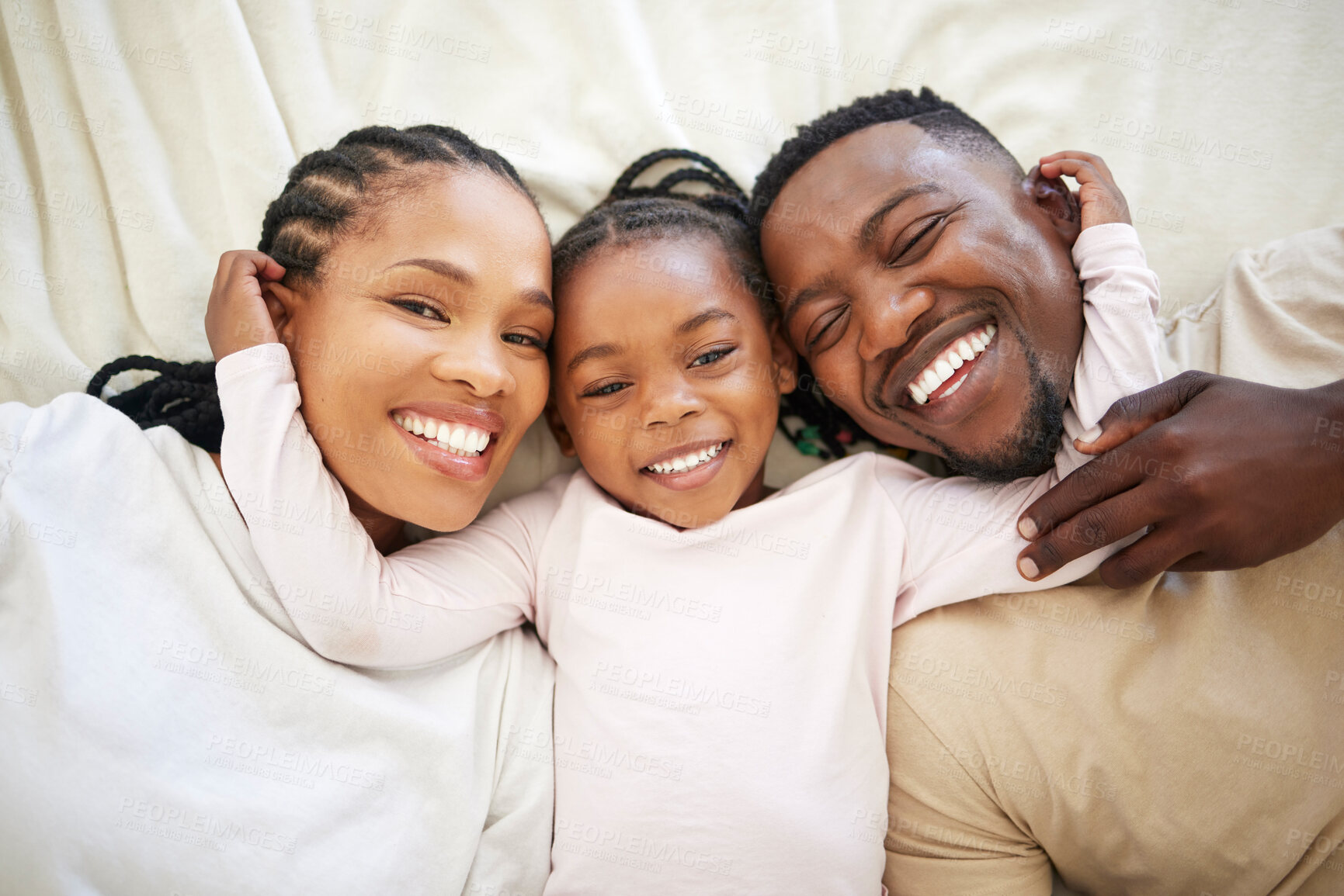 Buy stock photo Black family, portrait and happy kid in bedroom with parents to relax together in home above. Face, African mother and father with girl child in top view for bonding, laughing and embrace for support