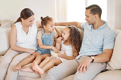 Buy stock photo Shot of a couple and their two daughters sitting on the couch at home