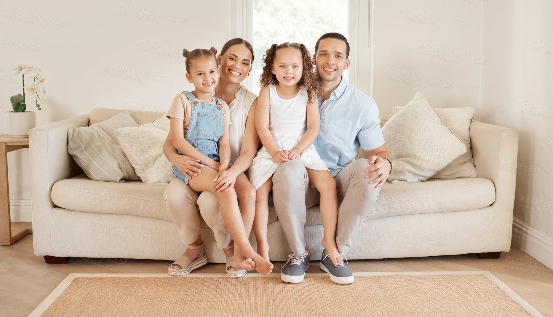 Buy stock photo Shot of a young couple bonding with their two young daughters at home