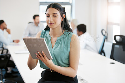 Buy stock photo Shot of a confident young businesswoman using a digital tablet in an office