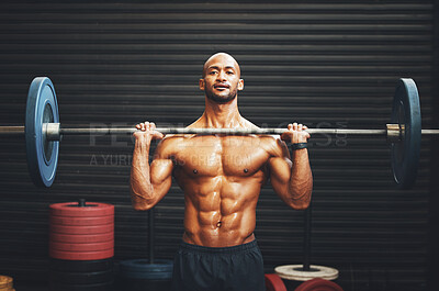 Buy stock photo Shot of a muscular young man exercising with a barbell in a gym